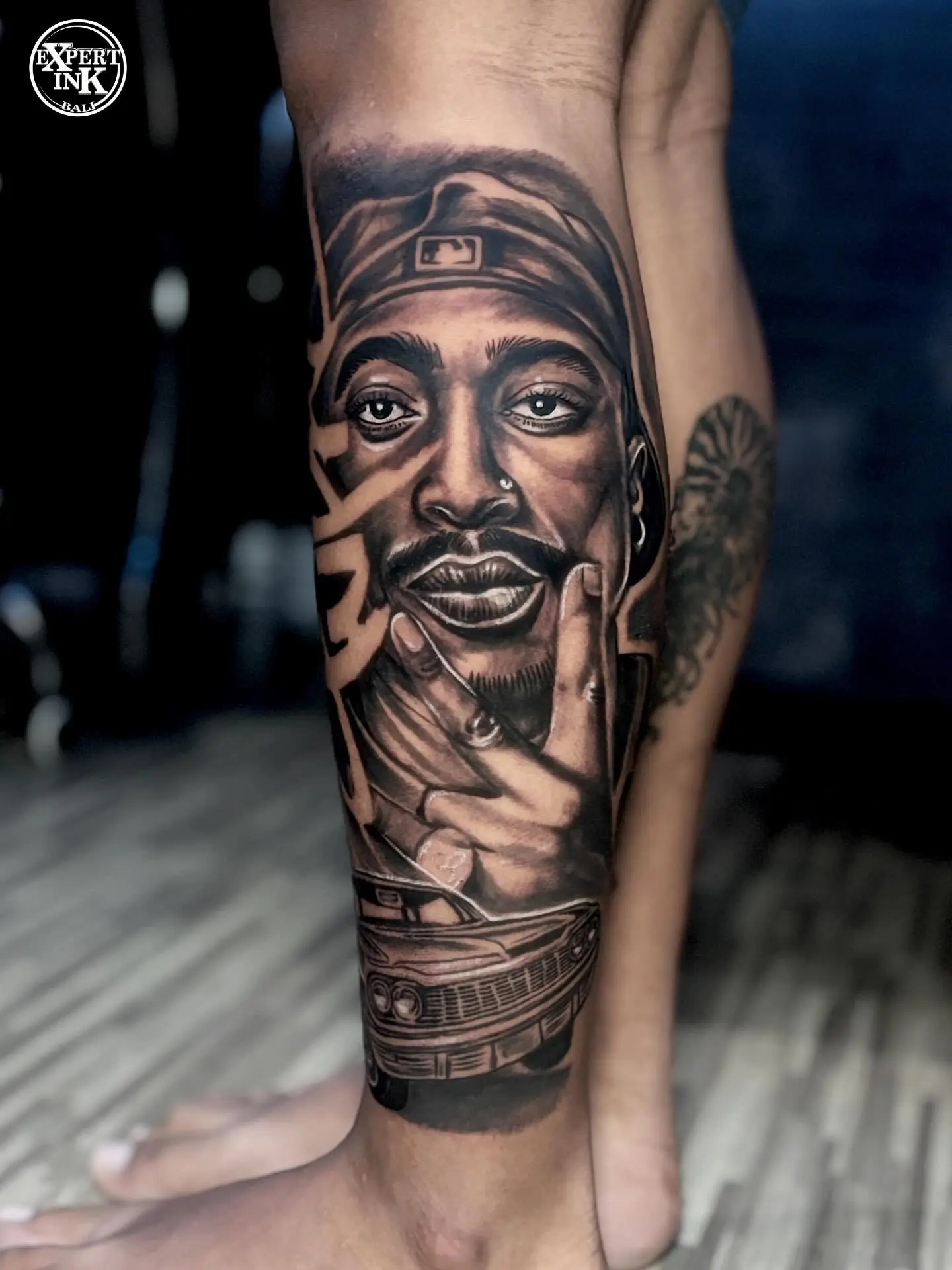 Black and grey portrait tattoo of a public figure on the leg