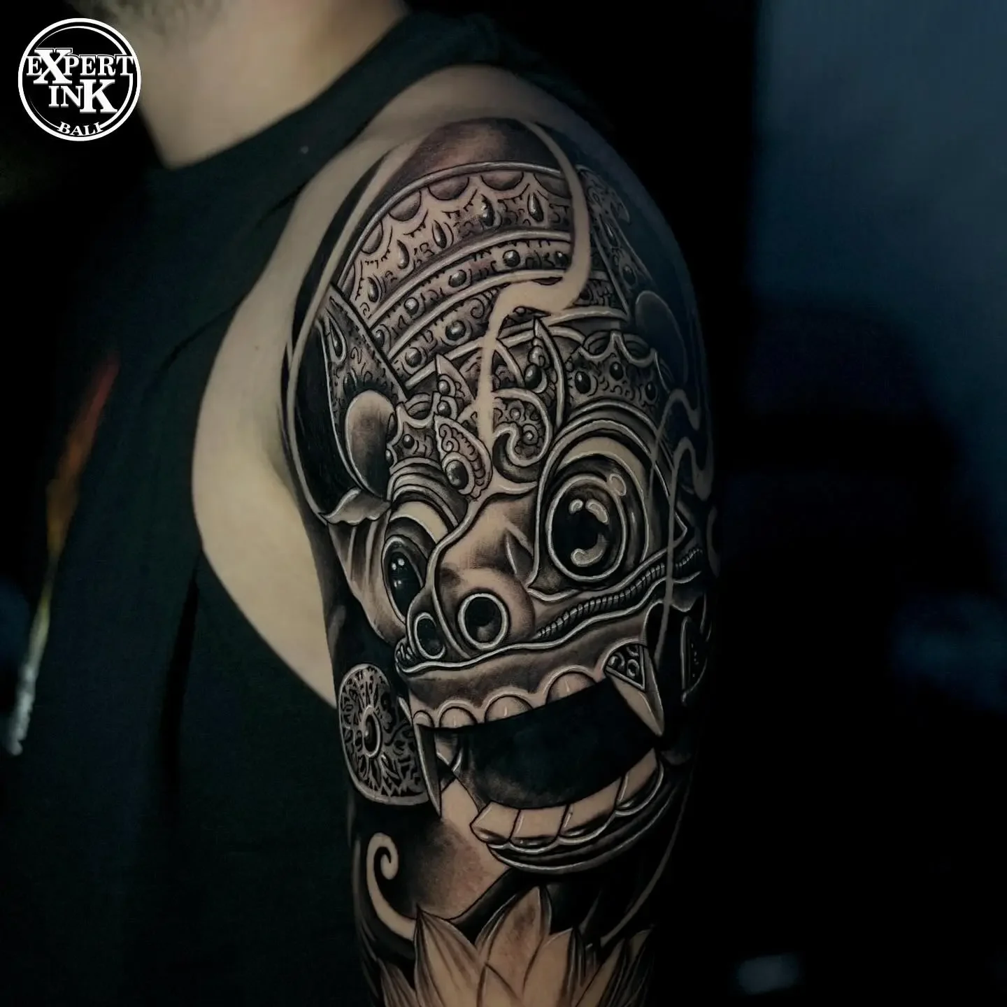 Close-up of a Balinese-style tattoo with intricate mythological line work