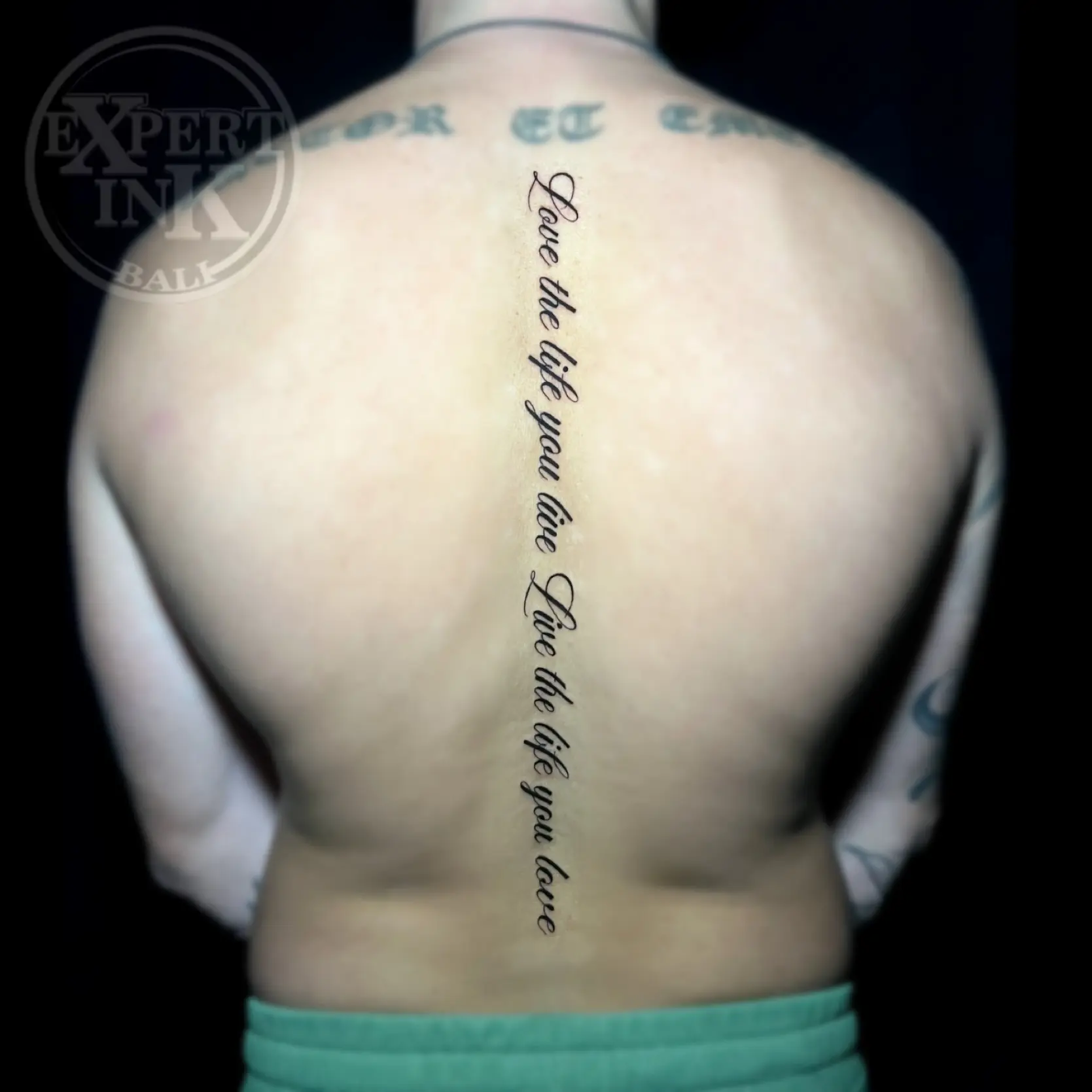 fine line back tattoo in Bali featuring artline and script